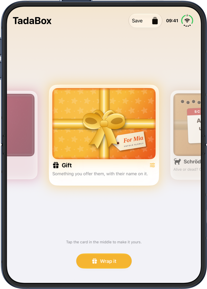 The setup on an open folding phone: the Gift card in the middle, wrapped in orange star paper with a tag for Mia, and the Wrap it button below